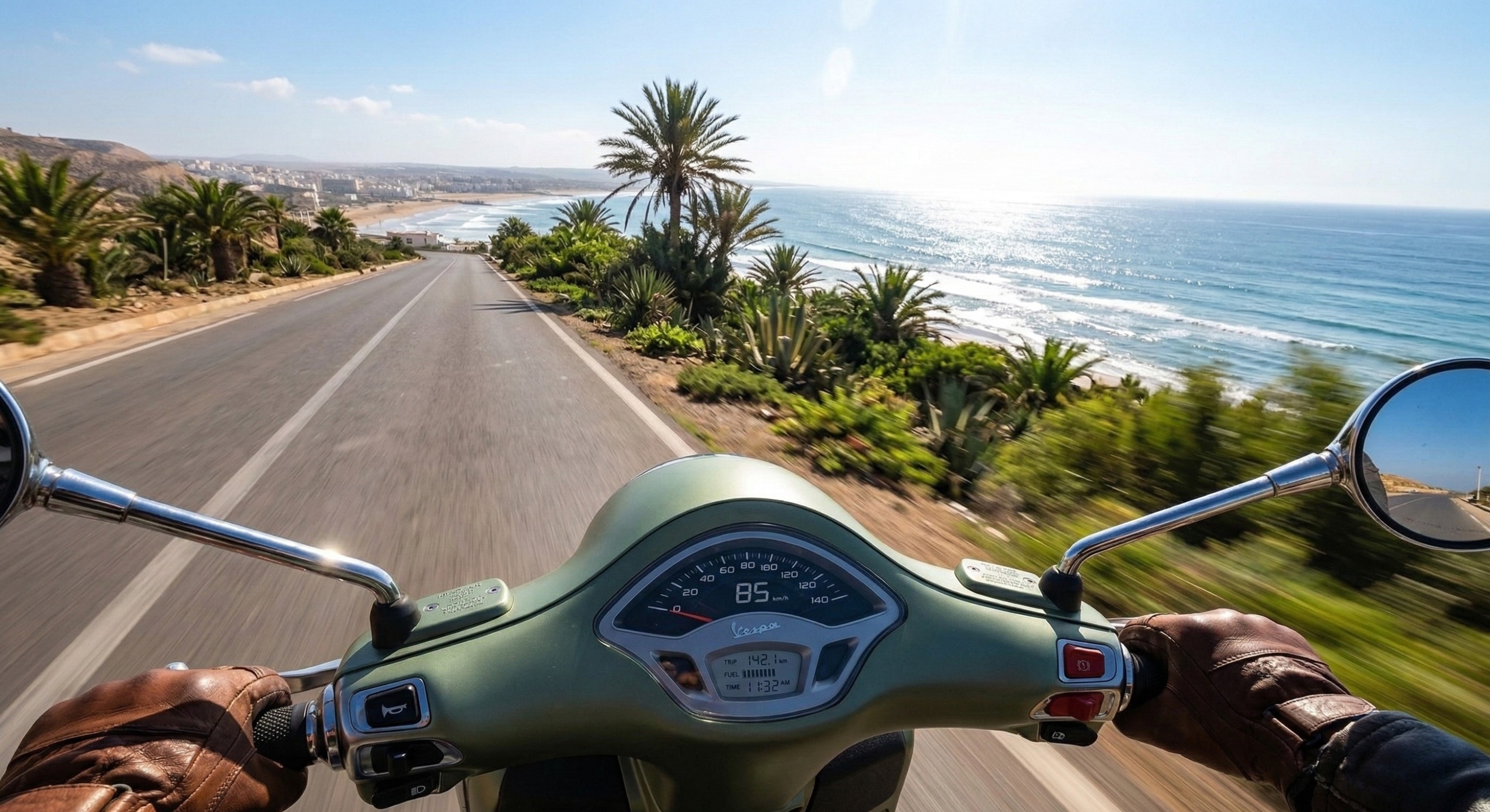 Riding a scooter along the coast road in Morocco to reach the best sunset viewpoints and surf spots in Tamraght