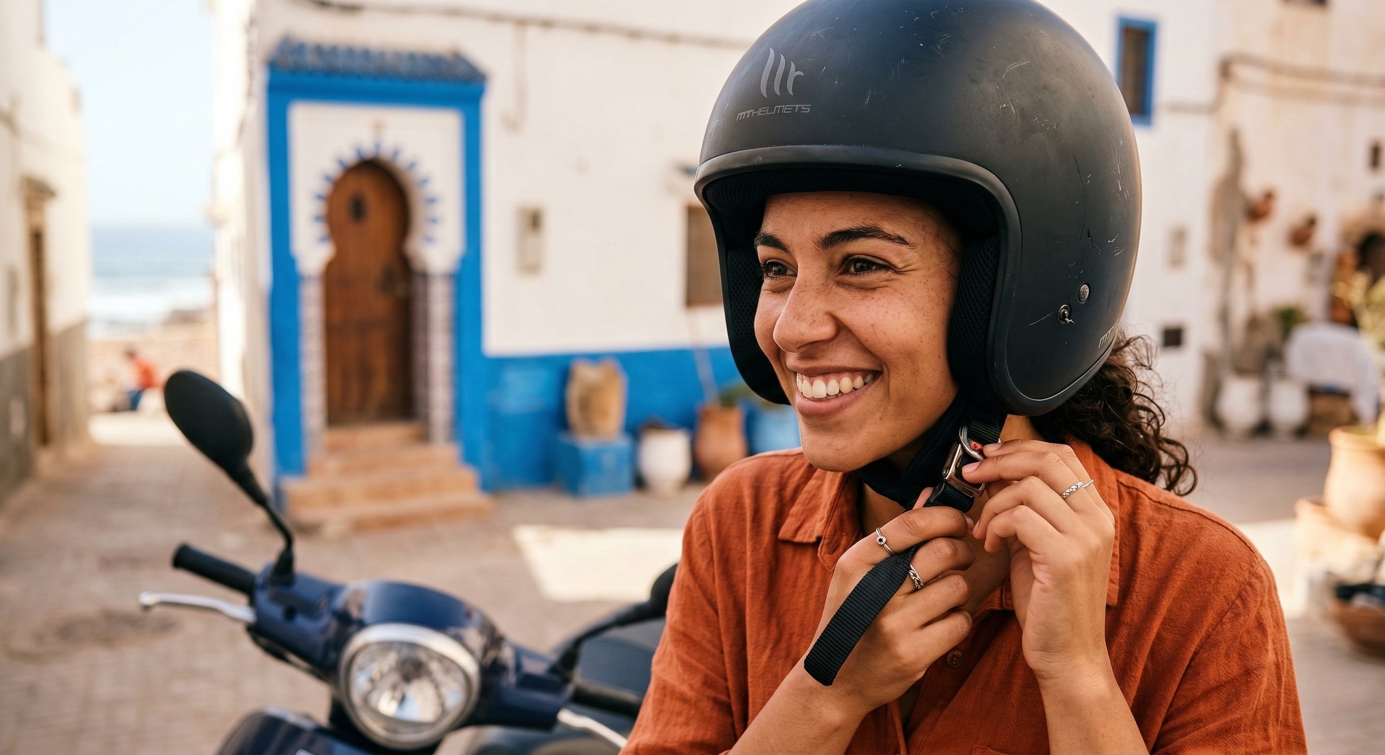 A tourist wearing a safety helmet while preparing to ride a scooter in Morocco